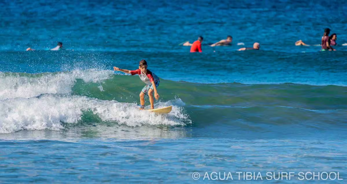Young surfer catching waves